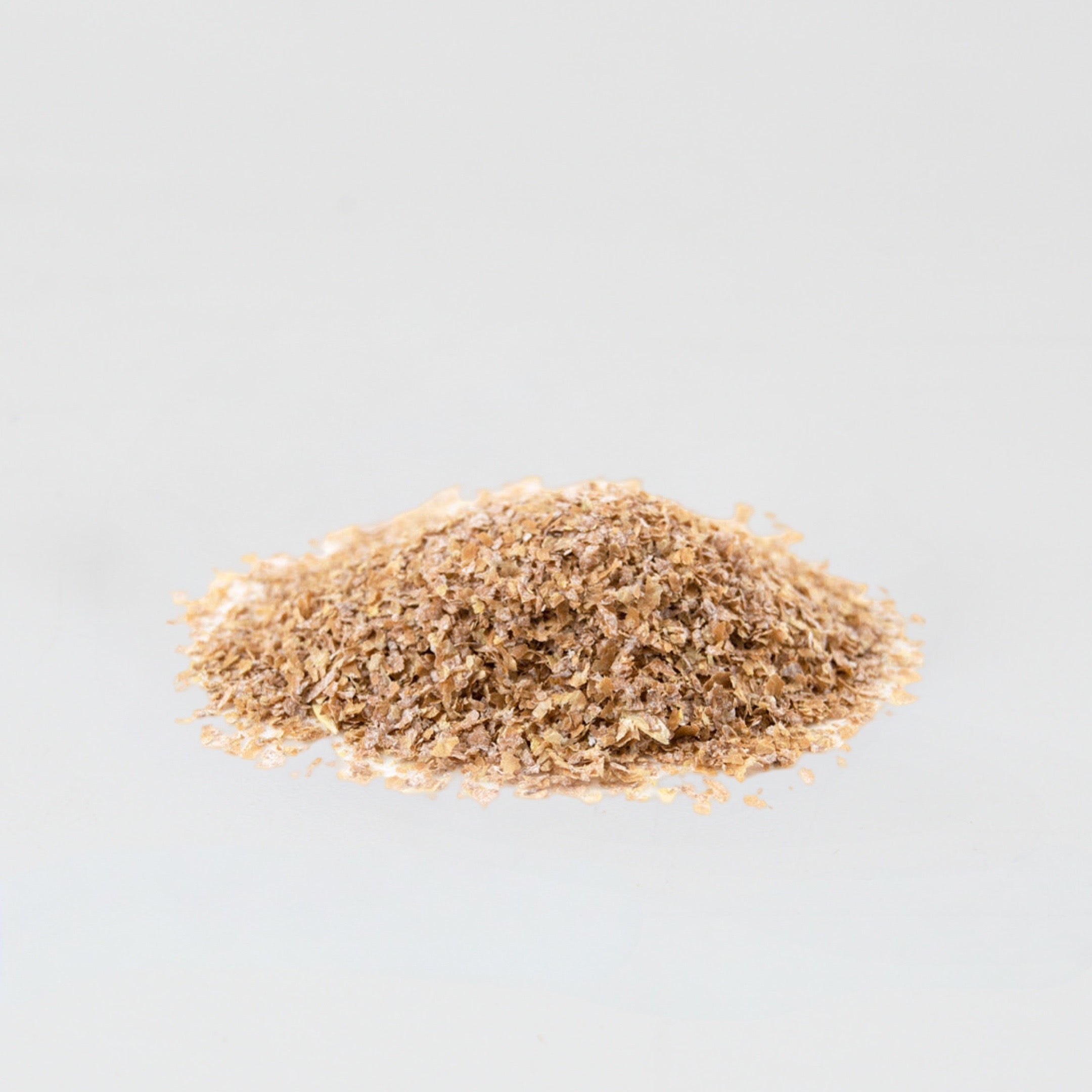 A little pile of coarse wheat bran on a white background